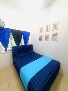 un letto blu in una stanza con finestra di LH Alisha Homestay Bandar Utama Gua Musang a Gua Musang