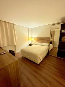 a bedroom with a bed and a large mirror at Umbu Hotel Porto Alegre - Centro Histórico - Prox Aeroporto 15min in Porto Alegre