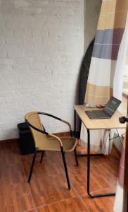 a table and a chair with a laptop on it at CASA VILLA SOL in Tumbes