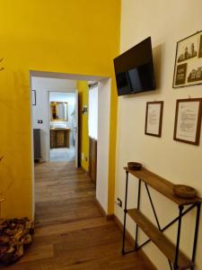 un corridoio con pareti gialle e una televisione su un muro di Corte Della Varesina a Milano