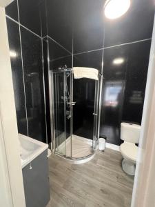 a bathroom with a shower and a toilet at Lauriston & Lawton Court Hotel in Llandudno