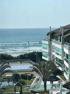 a building with a tennis court next to the ocean at Praia do Santinho, de frente para mar in Florianópolis