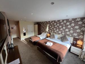 a hotel room with two beds and a flower wall at Lauriston & Lawton Court Hotel in Llandudno