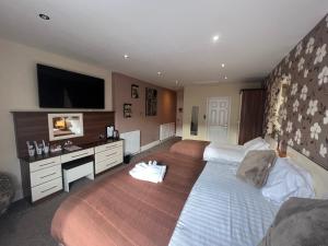 a hotel room with two beds and a desk at Lauriston & Lawton Court Hotel in Llandudno