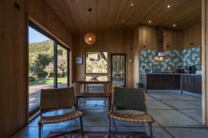 a kitchen with a table and two chairs in a room at Casas Martín Pescador, Lago Huillinco, Chiloe in Chonchi