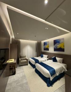 a hotel room with two beds and a television at الحزم للشقق الفندقية - الرياض - العليا in Riyadh