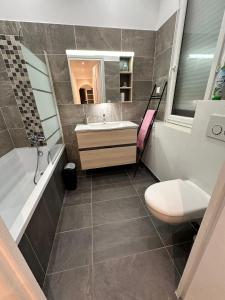 a bathroom with a sink and a tub and a toilet at Appartement T3 67m² in Perpignan