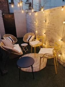 eine Gruppe von Stühlen und Tischen in einem Zimmer mit Beleuchtung in der Unterkunft Stylish 3BR house near Liverpool Football Club in Liverpool