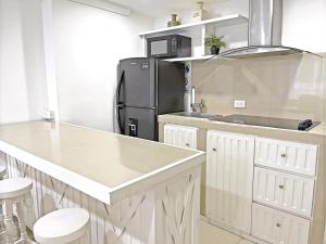 a kitchen with a black refrigerator and white cabinets at Espectacular Apartamento con Vista al Mar in San Andrés