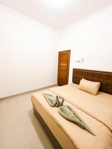 a bedroom with two beds with pillows on it at Homestay Kamar Tamu Godean in Godean