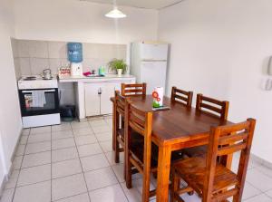 a kitchen with a wooden table and chairs in it at Departamento 2 Dormitorios Ruta 6 in General Roca