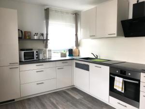 a kitchen with white cabinets and a stove top oven at Ferienhaus Bauer in Zirndorf