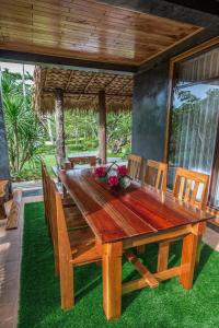 Andalay Beach Resort Koh Libong في ليبونغ: طاولة طعام وكراسي خشبية في الفناء