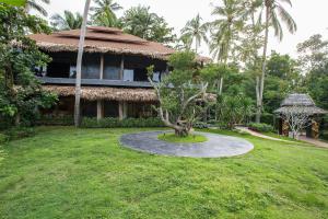una casa con un árbol delante de un patio en Andalay Beach Resort Koh Libong en Ko Libong