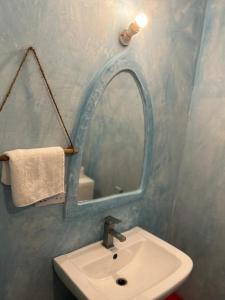 ein Bad mit einem Waschbecken und einem Spiegel in der Unterkunft Stonefish Inn Jambiani in Jambiani