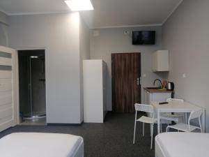 a small room with a table and a refrigerator at Hostel Anilux in Jelenia Góra
