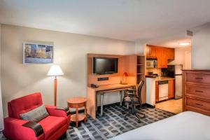 Cette chambre d'hôtel comprend un bureau et une chaise rouge. dans l'établissement TownePlace Suites by Marriott Baltimore BWI Airport, à Linthicum