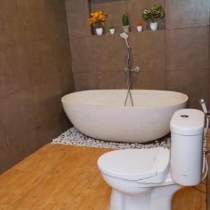 a bathroom with a bath tub and a toilet at Staycation in Style at Fya Home in Ciaterwadas