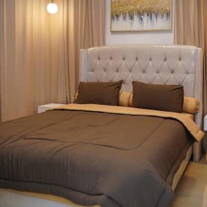 a bedroom with a large bed with a white headboard at Staycation in Style at Fya Home in Ciaterwadas