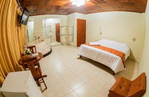 1 dormitorio con cama, bañera y lavamanos en Hotel Oro Verde & Suites en Iquitos