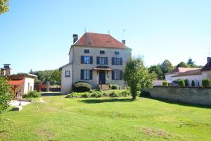 ein großes Haus mit einem Rasenplatz davor in der Unterkunft Le Moulin Du Landion Hôtel et Spa in Dolancourt