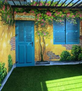 a house with a blue door and a tree painted on it at Tree Homestay in Da Nang