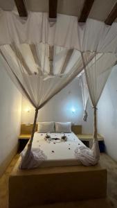 Schlafzimmer mit einem Bett mit Moskitonetzen in der Unterkunft Stonefish Inn Jambiani in Jambiani