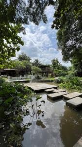 a pond with steps in the middle of a park at Shaya Suandoi Resort in Pai