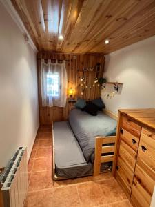 Cama pequeña en habitación con techo de madera en CAN VALERO, en Bagá
