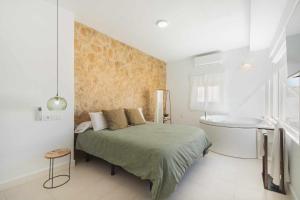um quarto com uma cama e uma banheira em Jacuzzi Amanecer de Plata Decoración Romántica em Chiclana de la Frontera