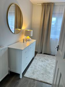 a bathroom with a white dresser and a mirror at House with garden and parking 15 min to City Center in Edinburgh