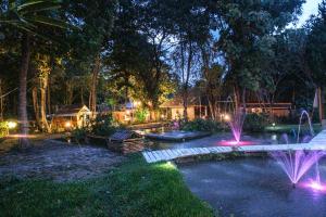 a backyard with a pond and fountain at night at Shaya Suandoi Resort in Pai