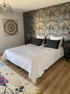 una camera da letto con un grande letto con lenzuola bianche di EMERAUDE a Saint-Cast-le-Guildo
