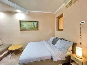 a bedroom with a bed and a couch at Apartment Centar in Podgorica