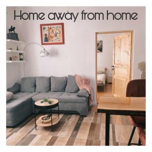 een woonkamer met een bank en een bord dat thuis weg van huis leest bij Home Away From Home - New Cosy Apartment Kruge in Zagreb