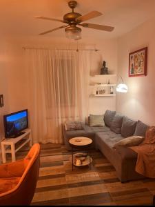 a living room with a couch and a ceiling fan at Home Away From Home - New Cosy Apartment Kruge in Zagreb