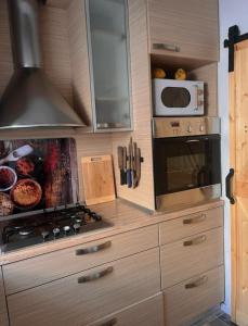 a kitchen with a stove and a microwave at Home Away From Home - New Cosy Apartment Kruge in Zagreb