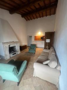 sala de estar con sofá y chimenea en La Casa di Vignoni Alto, en Bagno Vignoni