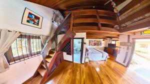 a living room with a spiral staircase in a tiny house at LINDA CASA EM SÃO BENTO DO SAPUCAI in São Bento do Sapucaí