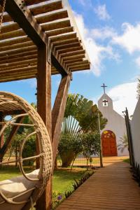 a wooden walkway with a church in the background at Pousada Luar da Ilha in Fernando de Noronha