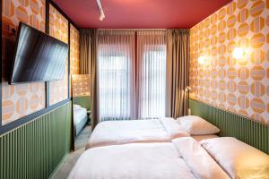 a bedroom with a bed and a flat screen tv at Budget Hotel Tourist Inn in Amsterdam