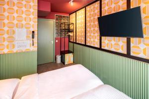 a bedroom with a bed and a flat screen tv at Budget Hotel Tourist Inn in Amsterdam