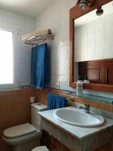 a bathroom with a sink and a toilet and a mirror at CASA MARTA duplex con piscina privada en Corralejo in Corralejo