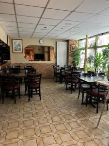 een eetkamer met tafels en stoelen in een restaurant bij Hôtel Jarry Confort in Parijs