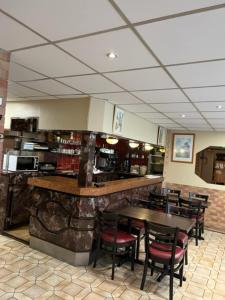 a restaurant with a bar with chairs and tables at H&ocirc;tel Jarry Confort in Paris