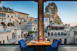 a table with blue chairs in front of a window at Carna Cave Hotel Cappadocia in Ortahisar
