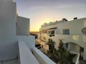 a view of a building with the sunset in the background at BREEZE VIEW house by the sea in Corralejo
