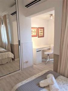 a bedroom with a bed and a desk and a mirror at BREEZE VIEW house by the sea in Corralejo
