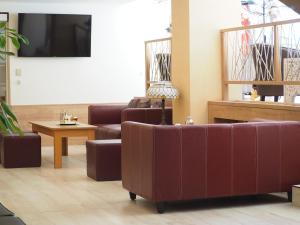 a waiting room with two couches and a tv at OÁZIS Hotel*** in Nagykanizsa