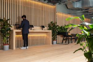 a man standing at a desk with a laptop at Zedwell Greenwich in London